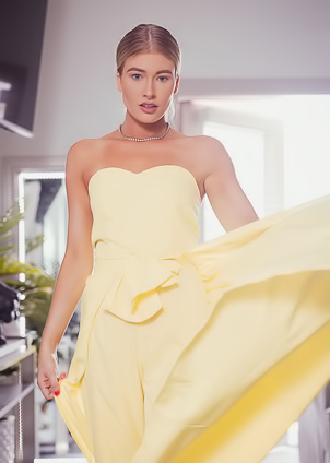 Tiana Jane poses for the camera, showing her small breasts and slim figure indoors